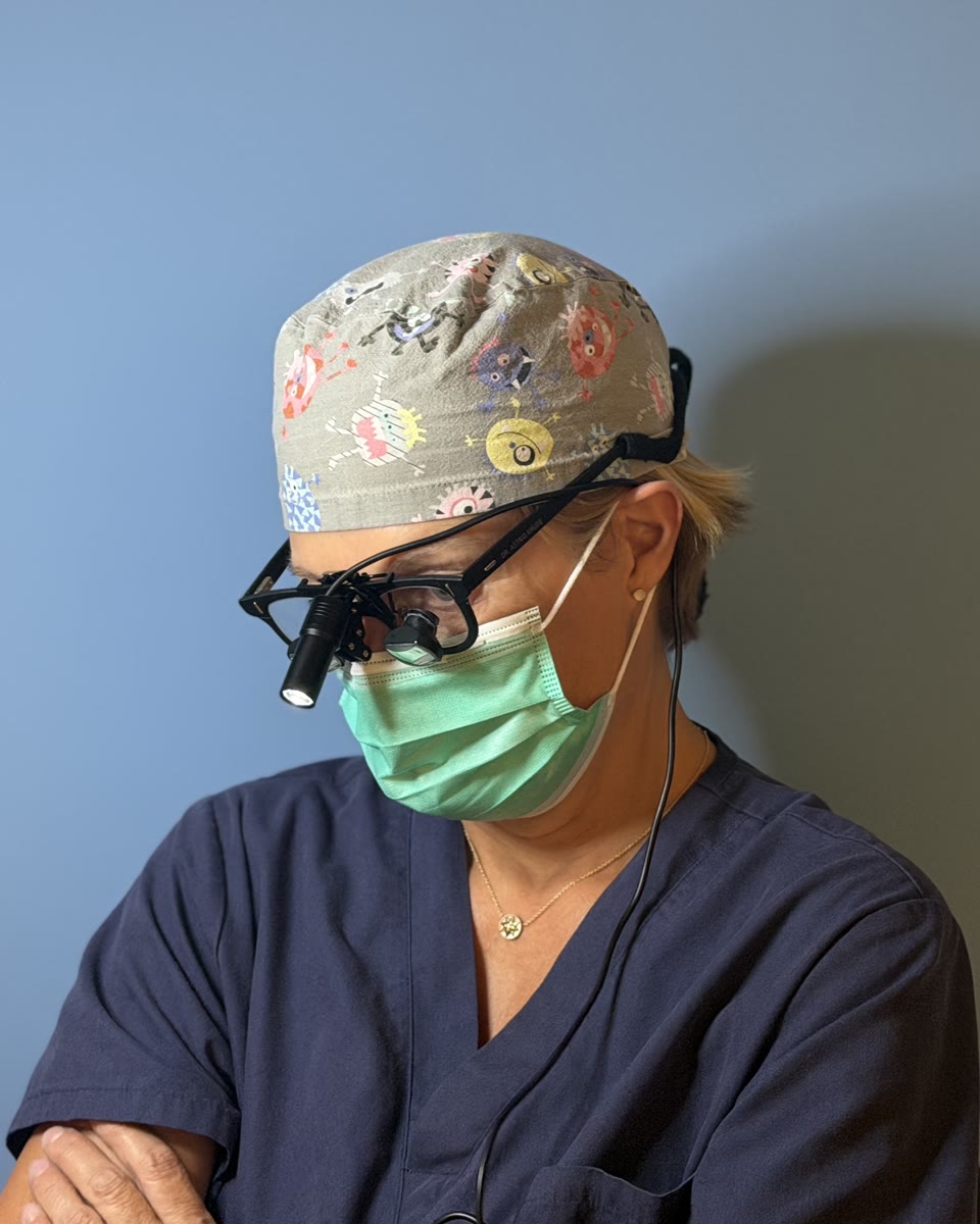 Astrid Kruse Gujer mit OP-Haube, Mundschutz und Lupenbrille